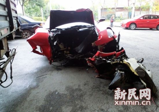 图说:记者在成都北路新闸路附近的事故停车场外找到了这辆红色法拉利。该车车头损毁十分严重,前保险杠扭成一团。新民晚报·新民网记者 左妍 摄 图说:记者在成都北路新闸路附近的事故停车场外找到了这辆红色法拉利。该车车头损毁十分严重,前保险杠扭成一团。新民晚报·新民网记者 左妍 摄