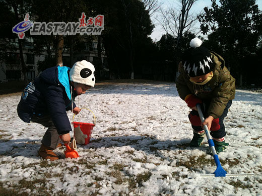 孩子们在难得一见的雪地上玩起铲雪的游戏。 孩子们在难得一见的雪地上玩起铲雪的游戏。