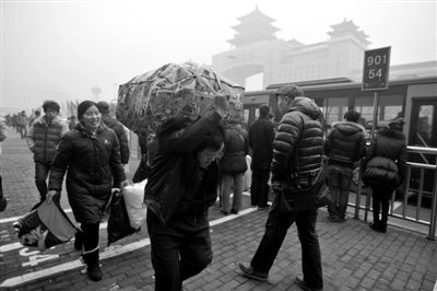 一名回家的旅客扛着行李前往北京西站 一名回家的旅客扛着行李前往北京西站