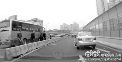 行车记录仪拍下了6名外籍人士在高架上集体小便的画面。/微博截图 行车记录仪拍下了6名外籍人士在高架上集体小便的画面。/微博截图