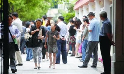 每年的 “小升初”报名期间,学校门口都会站满等待的家长。/晨报记者 吴磊 每年的 “小升初”报名期间,学校门口都会站满等待的家长。/晨报记者 吴磊