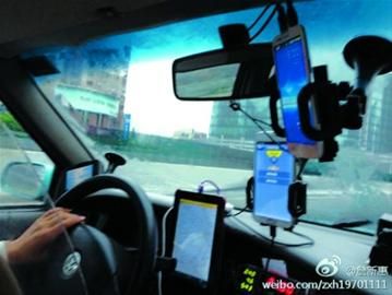 出租车前面挂满了移动终端/网友供图 出租车前面挂满了移动终端/网友供图
