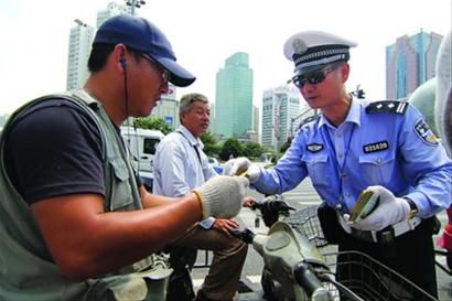 交警在给遵守交通秩序的人们奖励景点门票。 陈暐摄 交警在给遵守交通秩序的人们奖励景点门票。 陈暐摄