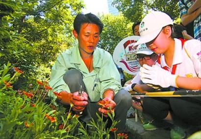 “小园丁”们正向园林师傅讨教花卉栽培的知识。 “小园丁”们正向园林师傅讨教花卉栽培的知识。