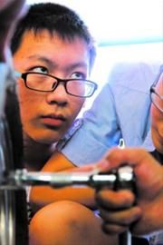 参加卡丁车维修体验的同学正在学习安装车轮胎。 参加卡丁车维修体验的同学正在学习安装车轮胎。