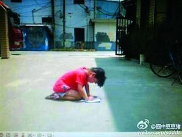 女孩跪在水泥地上写作业 /网友“圈中豆豆猪” 女孩跪在水泥地上写作业 /网友“圈中豆豆猪”