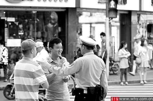 愚园路乌鲁木齐北路路口,交警在教育乱穿马路的年轻市民。青年报记者 丁嘉 摄 愚园路乌鲁木齐北路路口,交警在教育乱穿马路的年轻市民。青年报记者 丁嘉 摄