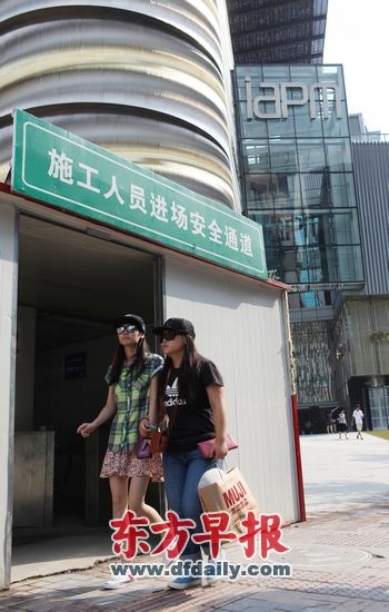 昨日,开始试营业的环贸iapm商场外,拎着购物袋的年轻女孩从工地通道旁走过。早报记者 王炬亮 图 昨日,开始试营业的环贸iapm商场外,拎着购物袋的年轻女孩从工地通道旁走过。早报记者 王炬亮 图