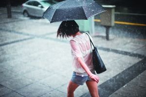 昨日,上海延安中路,一名女子撑伞在雨中行走.