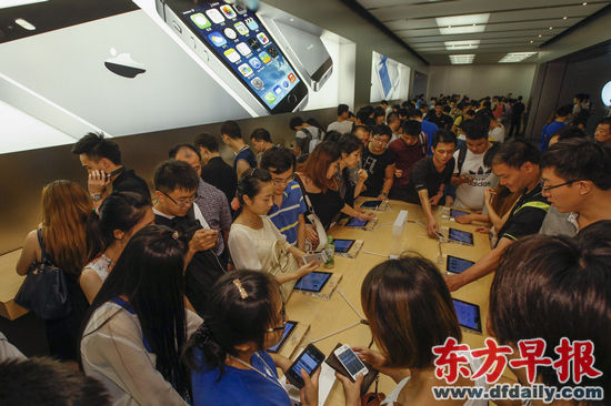 昨日,南京东路苹果直营店,顾客在体验iPhone 5s。 早报记者 徐晓林 图 昨日,南京东路苹果直营店,顾客在体验iPhone 5s。 早报记者 徐晓林 图