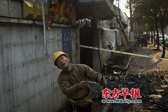 昨日,逸仙路1901号,一位电力抢修人员正在查看被烧断的电缆。早报记者 杨深来 图 昨日,逸仙路1901号,一位电力抢修人员正在查看被烧断的电缆。早报记者 杨深来 图