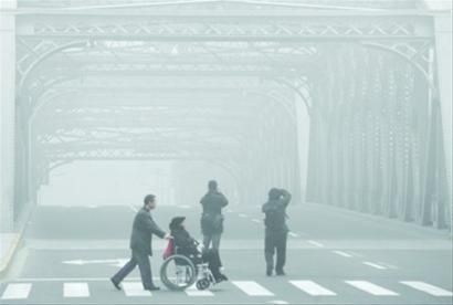 昨日下午2时,游客在外白渡桥上留影,大雾中的桥身若隐若现。 /张海峰 昨日下午2时,游客在外白渡桥上留影,大雾中的桥身若隐若现。 /张海峰