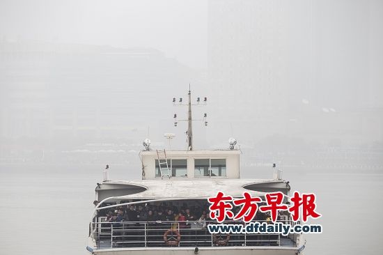昨日,上海一艘载满观光客的浦江渡轮行驶在雾霾中,岸上的建筑物若隐若现。 昨日,上海一艘载满观光客的浦江渡轮行驶在雾霾中,岸上的建筑物若隐若现。