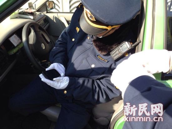 图说:交通执法人员正在对驾驶员违规使用打车软件的手机取证。新民网记者 李若楠 摄 图说:交通执法人员正在对驾驶员违规使用打车软件的手机取证。新民网记者 李若楠 摄