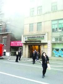 员工带着口罩从冒着烟的大楼内迅速疏散/现场图片 员工带着口罩从冒着烟的大楼内迅速疏散/现场图片