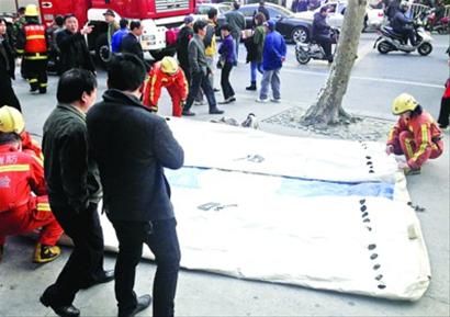 男子被劝下后,消防员将气垫打包。 /晨报记者 肖允 男子被劝下后,消防员将气垫打包。 /晨报记者 肖允