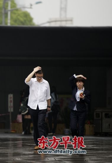 4月17日,上海五角场,两位市民同时用手遮雨。早报见习记者 吴子熙 图 4月17日,上海五角场,两位市民同时用手遮雨。早报见习记者 吴子熙 图