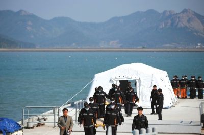 4月21日,在珍岛的一个港口,救援人员抬着“岁月”号沉没客轮遇难者遗体。新华社发 4月21日,在珍岛的一个港口,救援人员抬着“岁月”号沉没客轮遇难者遗体。新华社发