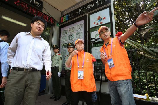 两名来自学校的平安志愿者穿上黄马甲、戴上红袖章,在地铁人民广场站出入口执勤。东方IC 图 两名来自学校的平安志愿者穿上黄马甲、戴上红袖章,在地铁人民广场站出入口执勤。东方IC 图