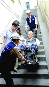 □在胶州路某弄,志愿者用“爬楼机”为老人服务。/孙鹏镖 □在胶州路某弄,志愿者用“爬楼机”为老人服务。/孙鹏镖