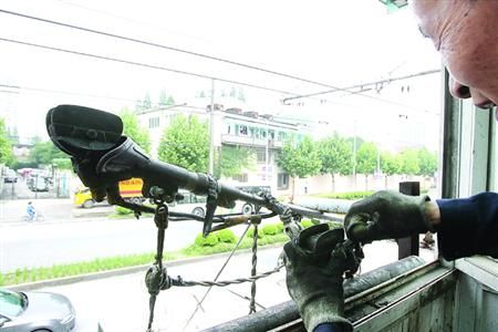 □14路老电车驶进江浦路终点站,维修工施师傅爬上5米高操作台为“小辫子”换上最后一块“煤精”。 /蒋迪雯 12 □14路老电车驶进江浦路终点站,维修工施师傅爬上5米高操作台为“小辫子”换上最后一块“煤精”。 /蒋迪雯 12