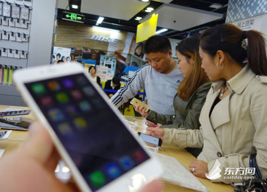 消费者在现场体验新款iPhone手机。