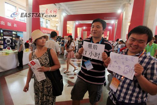展商手捧“最后一小时”的广告招揽读者。 展商手捧“最后一小时”的广告招揽读者。