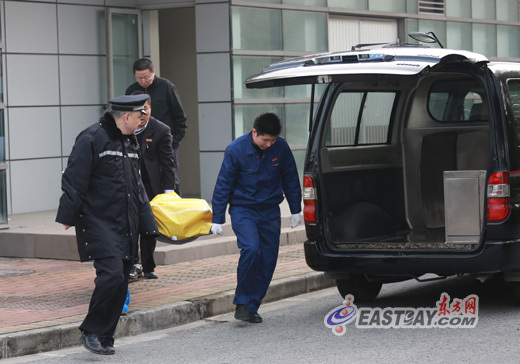 图为死者遗体被抬上殡仪车。 图为死者遗体被抬上殡仪车。