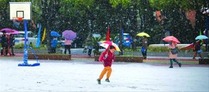 昨日,一名小学生在校园的操场上迎雪奔跑。/晨报记者 陈征 昨日,一名小学生在校园的操场上迎雪奔跑。/晨报记者 陈征