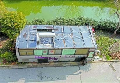 “房车”顶上安装了太阳能热水器与空调机箱,车主还在车前的空地上用铁栅栏围起了“自留地”。 本报记者 张海峰 通讯员 蔡斌 摄影报道 “房车”顶上安装了太阳能热水器与空调机箱,车主还在车前的空地上用铁栅栏围起了“自留地”。 本报记者 张海峰 通讯员 蔡斌 摄影报道