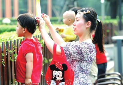 昨日高温,一位妈妈给孩子擦汗摇扇。□解放日报 陈 骏 摄 昨日高温,一位妈妈给孩子擦汗摇扇。□解放日报 陈 骏 摄