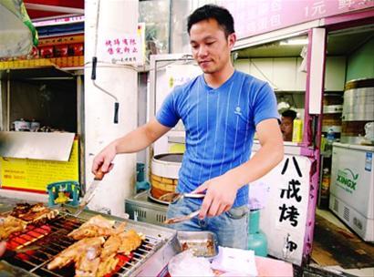 赖章平正在烤猪蹄。 岳诚 摄 赖章平正在烤猪蹄。 岳诚 摄