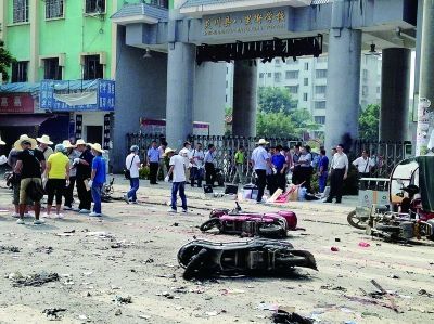 爆炸事故就发生在八里街学校门口,现场一片狼藉,相关人员正在现场善后。摄/孙盛峰 爆炸事故就发生在八里街学校门口,现场一片狼藉,相关人员正在现场善后。摄/孙盛峰