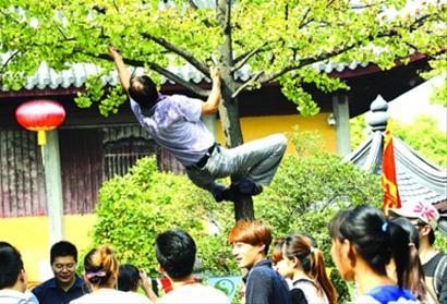 上海外滩,一名游客爬上雕塑。 晨报记者 杨眉 上海外滩,一名游客爬上雕塑。 晨报记者 杨眉
