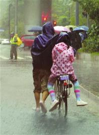 昨晨风雨中,市民艰难护送孩子上学。 昨晨风雨中,市民艰难护送孩子上学。