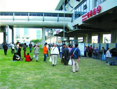 从轨交花桥站出来的乘客在草地上等候公交车。 本报记者 张家琳 摄 从轨交花桥站出来的乘客在草地上等候公交车。 本报记者 张家琳 摄