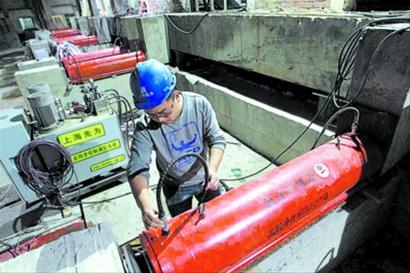 工程技术人员在检查平移大楼的千斤顶。 均本报记者 张海峰 摄 工程技术人员在检查平移大楼的千斤顶。 均本报记者 张海峰 摄