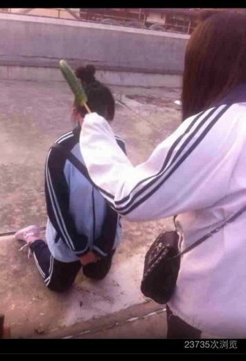 网上流传的照片显示,一名女生拿着黄瓜正教训跪在地上的女生。 网上流传的照片显示,一名女生拿着黄瓜正教训跪在地上的女生。