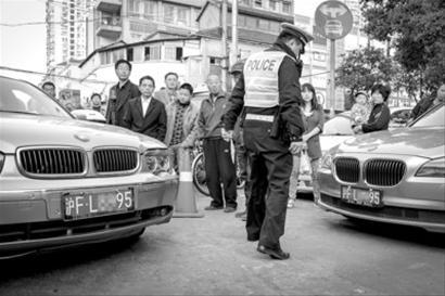 昨天下午,一交警在昆明路巡逻时发现两辆外形极为相似的宝马车,车牌竟完全一样。/晨报记者 肖允 昨天下午,一交警在昆明路巡逻时发现两辆外形极为相似的宝马车,车牌竟完全一样。/晨报记者 肖允